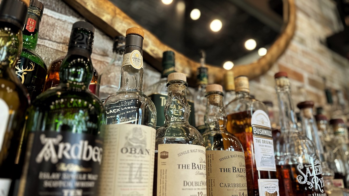 liquor bottles in front of mirror at a cocktail bar