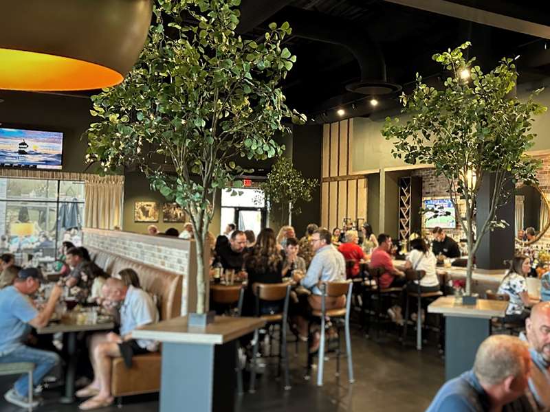 restaurant with warm atmosphere filled with people talking and eating at tables